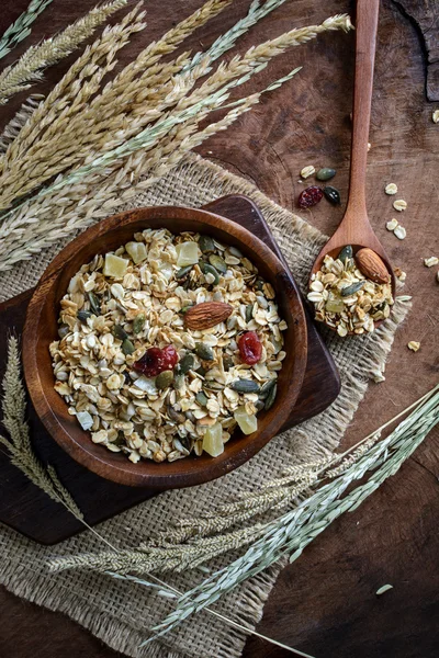 Copo de avena y granos de trigo integral en cuenco de madera sobre mesa de madera —  Fotos de Stock