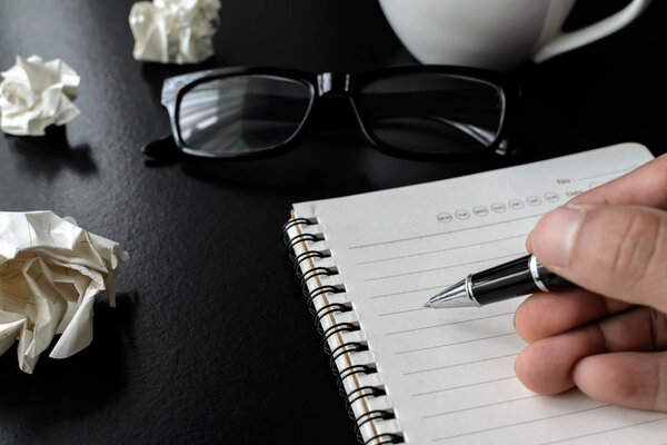 Crumpled paper balls with eye glasses and hand writing