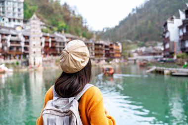 Feng Huang Antik Kasabası 'nın güzel manzarasına bakan genç bayan turist Hunan Eyaleti, Çin' deki ünlü turizm merkezi.