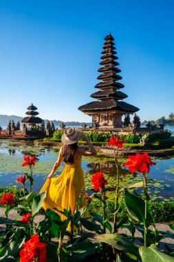 Endonezya 'nın Bali kentindeki Ulun Danu Beratan tapınağındaki güzel manzaranın tadını çıkaran genç bayan turist.
