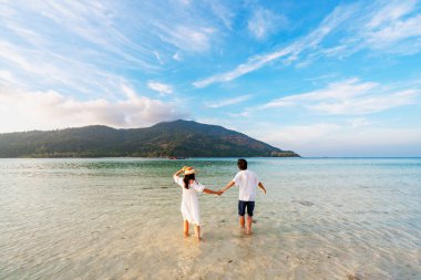 Genç çift gezgin dalgalı, şeffaf deniz, yaz tatili ve seyahat konseptiyle tropikal beyaz kumsalda dinleniyor ve eğleniyor.