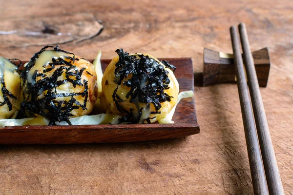 Poffertjespan op houten tafel met stokjes, Japans eten — Stockfoto