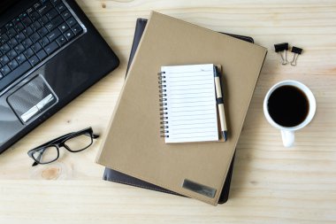 Kahve ve ahşap masa laptop ile klasör yığını