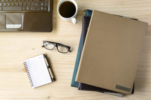 Stack av mappen med kaffe och laptop på trä skrivbord — Stockfoto