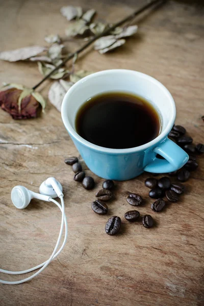 Auricular con café en la vieja mesa de madera —  Fotos de Stock