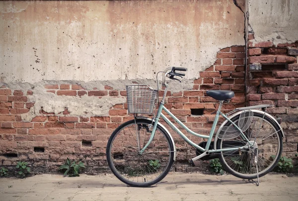 Zabytkowy rower ze starą ceglaną ścianą — Zdjęcie stockowe