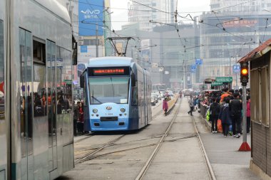 Kalabalık yolcuların tramvay için bekliyor. Tramvay Dalian, Çin için taşıma sistemi biridir
