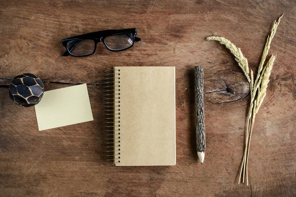 Cuaderno de notas en blanco con anteojos y lápiz sobre un escritorio de madera viejo — Foto de Stock