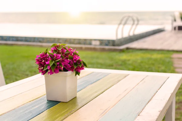 Mazzo di fiori su tavolo in legno con luce soffusa — Foto Stock