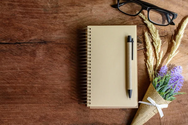 Cuaderno en blanco con flor sobre mesa de madera — Foto de Stock