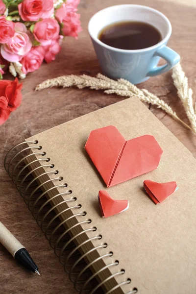 Tasse Kaffee mit Blume und rotem Herzpapier und Notizblock — Stockfoto