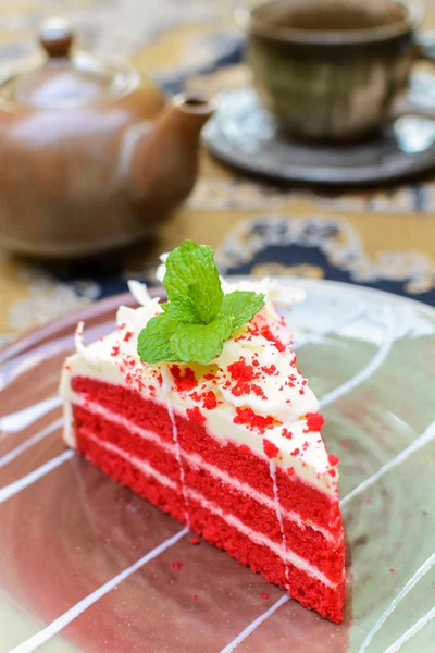 Red velvet cake with cup of tea and kettle