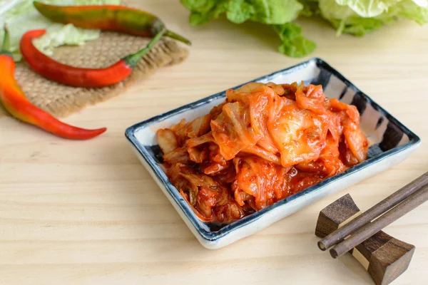 Kimchi mit Stäbchen auf Holztisch, koreanisches traditionelles Essen — Stockfoto