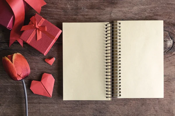 Cuaderno en blanco con caja de regalo roja y flor sobre fondo de madera —  Fotos de Stock