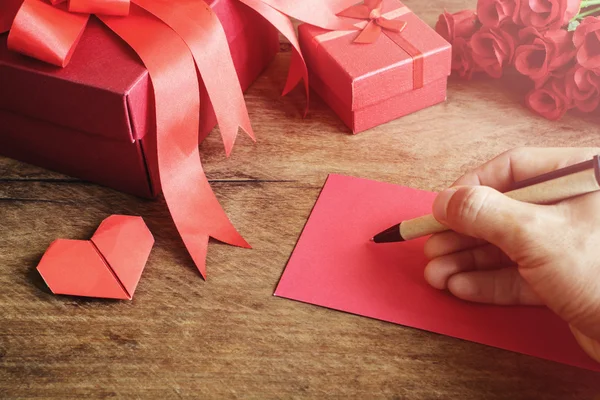 Handschrift auf Notizbuch mit rotem Geschenkkarton und Blume auf Holz — Stockfoto