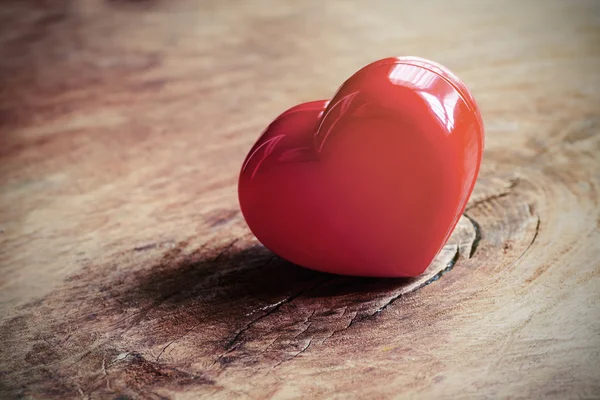 Красное сердце на старом деревянном столе — стоковое фото