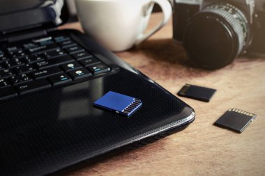 dizüstü bilgisayar, kamera ve bir fincan kahve ahşap masa