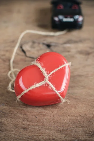 Coração que amarrado com corda é reboque por carro esporte — Fotografia de Stock
