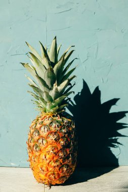 Gölgeli büyük olgun ananas, tropikal temalı ahşap arkaplan üzerine kopyalama alanı