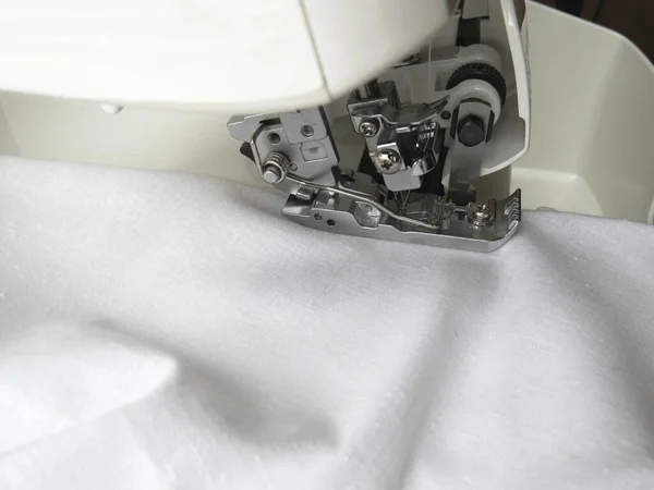 这种上锁缝纫机缝制白色面料 服装业 — 图库照片