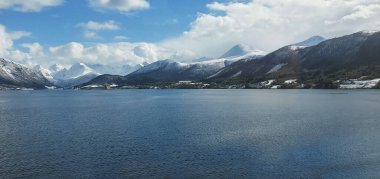 Enfes Norveç dağlarının, denizin ve bulutlu gökyüzünün güzel manzarası