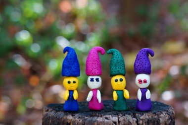 Dört peri masalı cücesinin figürleri. Renkli bir arka planda, ormanda plastikten yapılmış..