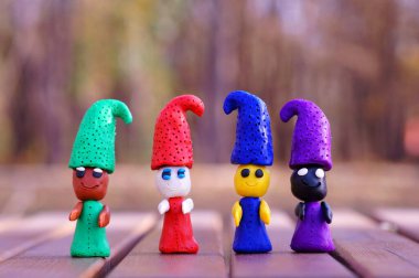 Renkli bir arka planda dört renkli plastik cüce..