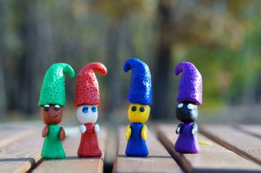 Renkli bir arka planda dört renkli plastik cüce..