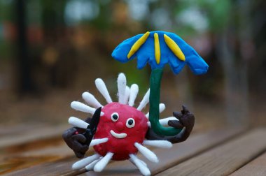 Oyuncak bıçak ve şemsiyeyle plastikten yapılmış virüs heykelciği..
