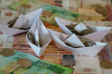 Bozuk paralarla dolu birkaç kağıt tekne. Mali sembol.