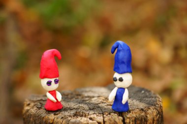 Renkli bir arka planda ormanda iki plastik cüce..