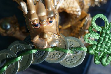 Ejderha heykelciğine yakın çekim. Ejderhanın dişinde bir demet Çin parası var. Refahın ve parasal refahın sembolü..