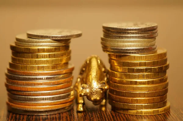 Metal bull with coins on a gold background. Financial symbol.