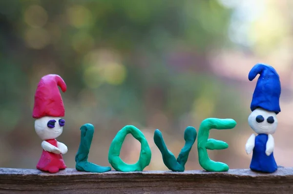 Renkli Bir Arka Planda Iki Plastik Cüce Yanındaki Kutsal Aşk — Stok fotoğraf