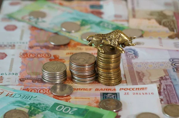 Metal bull with coins on the table.