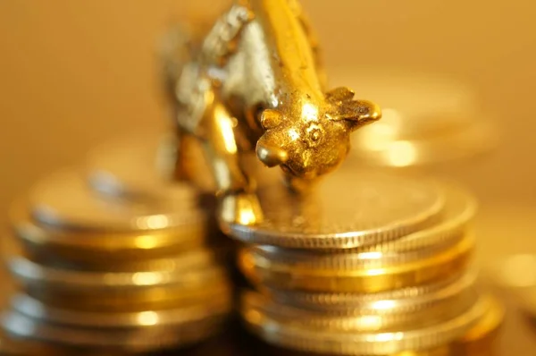 Metal bull with coins on the table. Financial symbol.