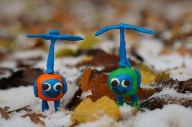 Oyuncak helikopter karla kaplı çimlerde.