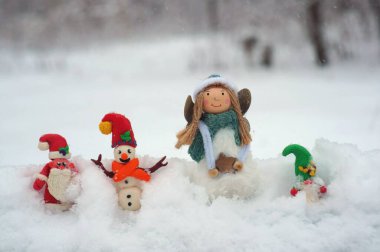 Noel Baba, kardan adam ve kardan cüce figürü. Yakınlarda bir Noel meleği var.