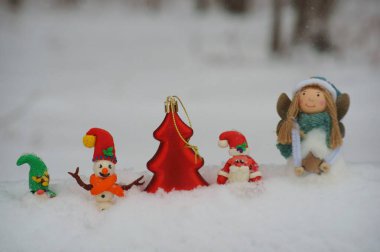 Noel Baba, kardan adam ve kardan cüce figürü. Yakınlarda bir Noel meleği var. Kış ormanlarındaki peri masalı karakterleri..
