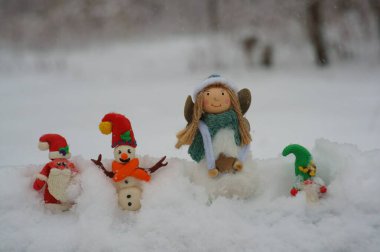 Noel Baba, kardan adam ve kardan cüce figürü. Yakınlarda bir Noel meleği var.