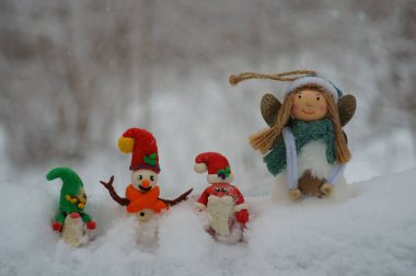 Noel Baba, kardan adam ve kardan cüce figürü. Yakınlarda bir Noel meleği var. Kış ormanlarındaki peri masalı karakterleri..