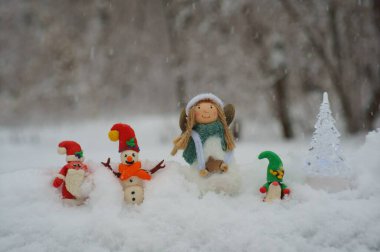 Noel Baba, kardan adam ve kardan cüce figürü. Yakınlarda bir Noel meleği var. Kış ormanlarındaki peri masalı karakterleri..