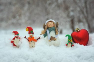 Noel Baba, kardan adam ve kardan cüce figürü. Yakınlarda bir Noel meleği var. Kış ormanlarındaki peri masalı karakterleri..