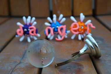 Virüsün figürleri ve yazıt tehlikesi. Yanında küçük cam bir küre var..