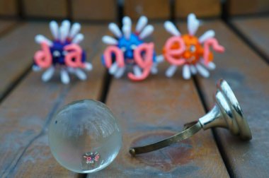 Virüsün figürleri ve yazıt tehlikesi. Yanında küçük cam bir küre var..