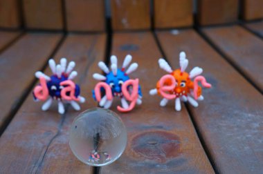 Virüsün figürleri ve yazıt tehlikesi. Yanında küçük cam bir küre var..