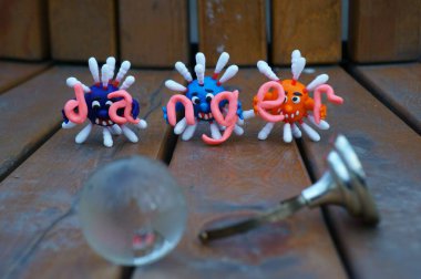 Virüsün figürleri ve yazıt tehlikesi. Yanında küçük cam bir küre var..