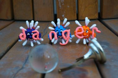 Virüsün figürleri ve yazıt tehlikesi. Yanında küçük cam bir küre var..