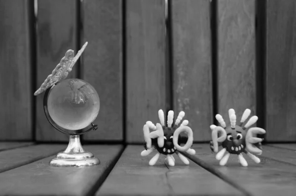 Mały Szklany Kula Zabawkowy Motyl Obok Dwóch Postaci Wirusa Nadziei — Zdjęcie stockowe