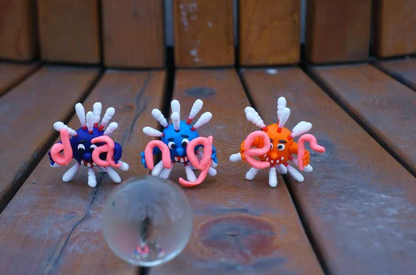 Virüsün figürleri ve yazıt tehlikesi. Yanında küçük cam bir küre var..